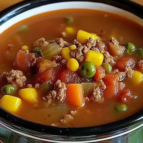 Bowl of hearty crock pot cowboy soup with colorful vegetables and beans
