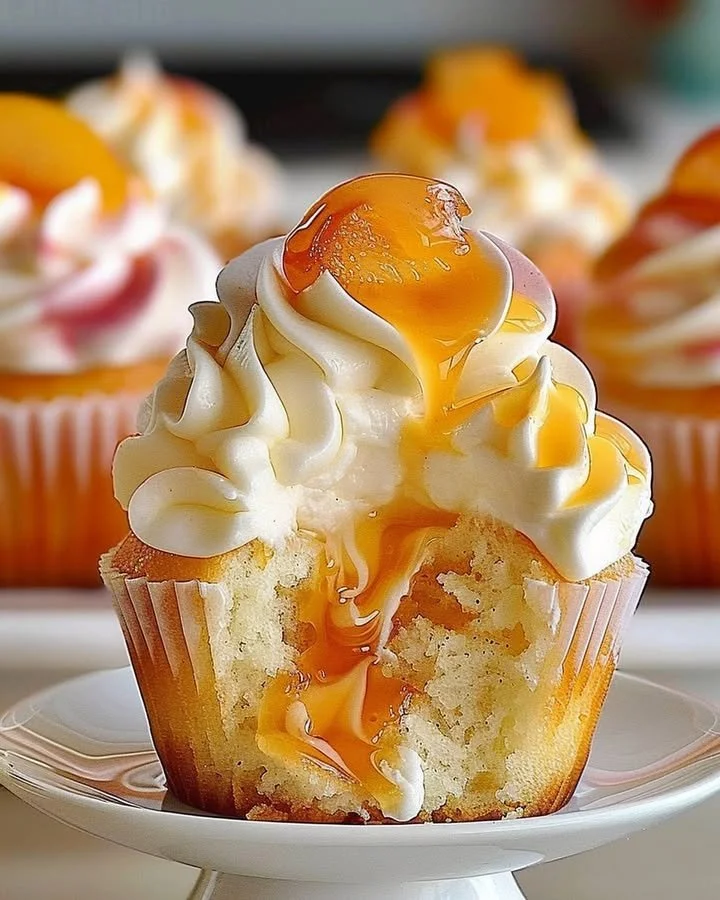 Delicious homemade peach cupcakes topped with creamy frosting and fresh peach slices.