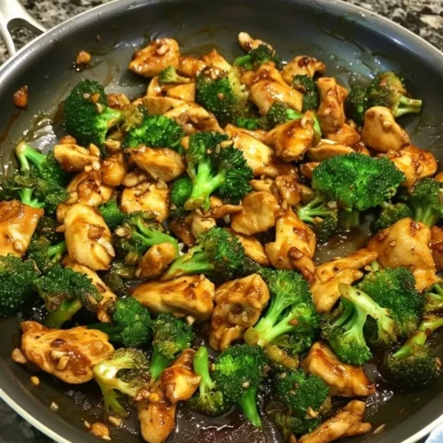 Plate of Szechuan-Style Chicken with Broccoli garnished with herbs.