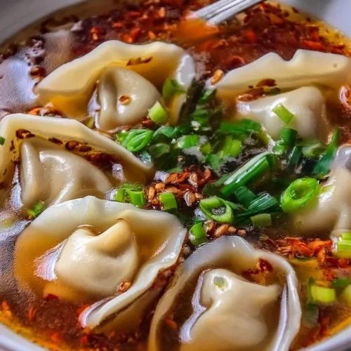 Bowl of homemade weeknight wonton soup with fresh vegetables and dumplings